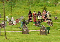 Kvinnene står litt unna under begravelseseremonien. Foto: NRK